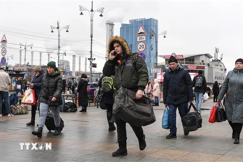 Người dân mang theo hành lý di chuyển gần nhà ga ở thủ đô Kiev, Ukraine ngày 24/2/2022. (Ảnh: AFP/TTXVN) 