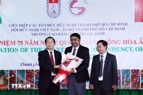 Ông Huỳnh Thành Lập (ngoài cùng bên trái), Chủ tịch Hội hữu nghị Việt Nam-Ấn Độ Thành phố Hồ Chí Minh, tặng hoa chúc mừng Tổng Lãnh sự Ấn Độ tại Thành phố Hồ Chí Minh Madan Mohan Sethi (giữa) tại buổi lễ. (Ảnh: Xuân Khu/TTXVN) 