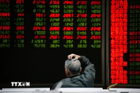Nhà đầu tư theo dõi bảng chỉ số chứng khoán tại Bắc Kinh, Trung Quốc. (Ảnh: AFP/TTXVN) 