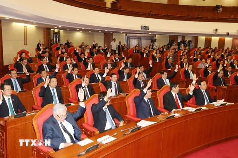 Các đồng chí lãnh đạo Đảng, Nhà nước và các đại biểu biểu quyết thông qua Nghị quyết Hội nghị Trung ương lần thứ mười hai. (Ảnh: Trí Dũng/TTXVN)