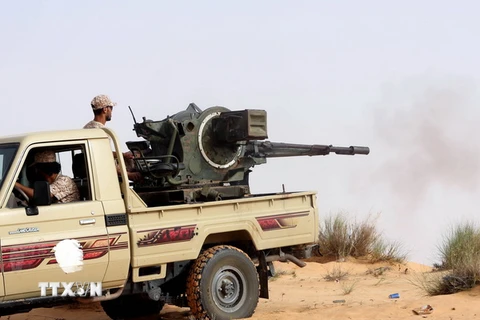 Các tay súng thuộc Bình minh Libya giao tranh với lực lượng trung thành với Chính phủ được quốc tế công nhận của Libya. (Ảnh: AFP/TTXVN)