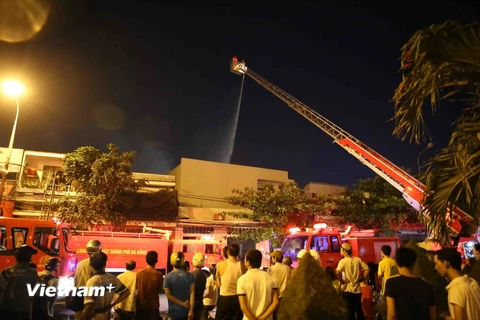 Lực lượng cứu hỏa sử dụng xe thang tiếp cận hiện trường dập lửa. (Ảnh: Trần Lê Lâm/Vietnam+)