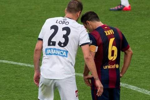 Trung vệ Alberto Lopo to nhỏ với Xavi trong trận đấu cuối cùng của La Liga. (Ảnh: Mundodeportivo.com)
