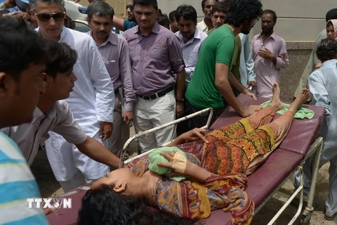 Chuyển nạn nhân bị đột quỵ do nắng nóng tại thành phố Karachi ngày 24/6. (Ảnh: AFP/TTXVN)