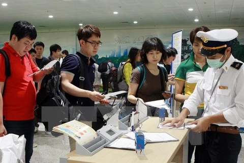 Hành khách từ Hàn Quốc nhập cảnh đến Việt Nam thực hiện kê khai tờ khai y tế. (Ảnh: Dương Ngọc/TTXVN)