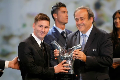Lionel Messi nhận phần thưởng “Cầu thủ xuất sắc nhất” từ Chủ tịch UEFA Michel Platini. (Ảnh: AP)