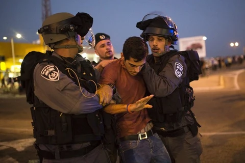 Cảnh sát Israel bắt giữ một thanh niên Palestine. (Ảnh: Reuters)