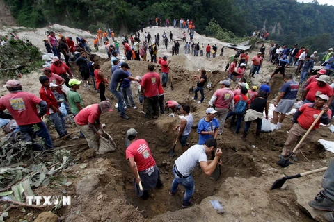 Lực lượng cứu hộ tìm kiếm người mất tích trong vụ lở đất tại làng El Cambray ngày 2/10. (Ảnh: Reuters/TTXVN)