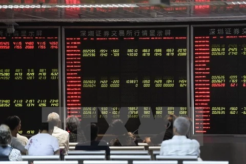 Nhà đầu tư theo dõi bảng tỷ giá chứng khoán tại thủ đô Bắc Kinh, Trung Quốc. (Nguồn: AFP/TTXVN)
