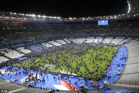 Khán giả tràn xuống sân Stade de France sau khi nghe tin về các vụ tấn công. (Ảnh: AP)