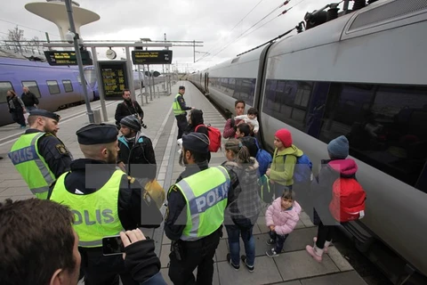 Cảnh sát Thụy Điển kiểm tra nhóm người nhập cư tại sân ga ở Malmo. (Nguồn: AFP/TTXVN)