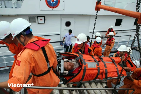 Chuyển nạn nhân từ tàu SAR 412 lên bờ. (Ảnh: Trần Lê/Vietnam+)