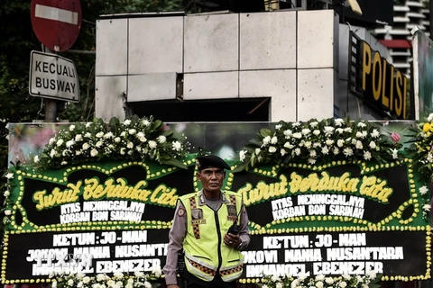 Cảnh sát Indonesia gác trước khu vực đặt hoa tưởng niệm các nạn nhân vụ tấn công ở Jakarta ngày 15/1. (Ảnh: AFP/TTXVN)