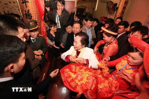 Phó Chủ tịch nước Nguyễn Thị Doan phát lương cho nhân dân tại đền Trần Thương. (Ảnh: TTXVN)