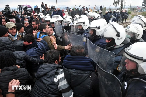 Cảnh sát Hy Lạp ngăn những người biểu tình tại biên giới với Macedonia, gần làng Idomeni ngày 27/3. (Ảnh: AFP/TTXVN)