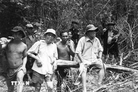 Ông Lê Quang Nghĩa (áo trắng, đứng giữa) trong một lần băng rừng tìm hài cốt đồng đội. (Nguồn: TTXVN)
