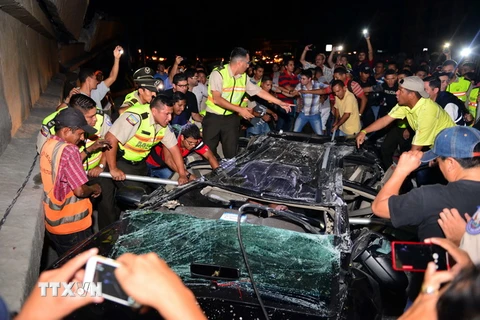 Nhân viên cứu hộ và các tình nguyện viên giải cứu nạn nhân bị mắc kẹt trong ôtô sau trận động đất ở Guayaquil, Ecuador. (Nguồn: AFP/TTXVN)