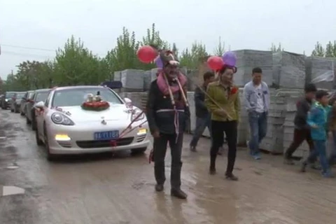 Bố mẹ chú rể hóa trang thành lừa kéo xe chở con dâu. (Nguồn: CCTV News)