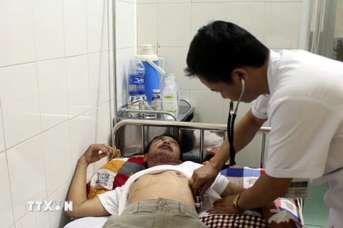 Bác sỹ Bệnh viện Đa khoa thành phố Vinh (Nghệ An) đang thăm khám cho anh Trương Như La. (Ảnh: Tá Chuyên/TTXVN)
