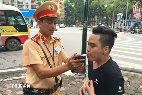 Cảnh sát giao thông Hà Nội tiến hành kiểm tra nồng độ cồn của điều khiển phương tiện tại ngã tư Trần Hưng Đạo-Lê Thánh Tông. (Ảnh: Doãn Tấn/TTXVN)