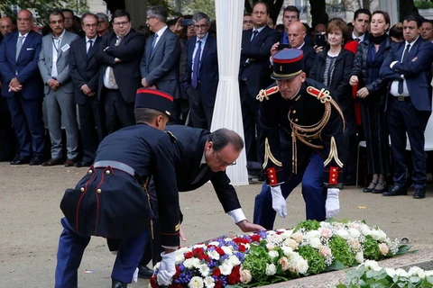 Tổng thống Pháp François Hollande đặt hoa tưởng nhớ các nạn nhân. (Nguồn: Reuters)