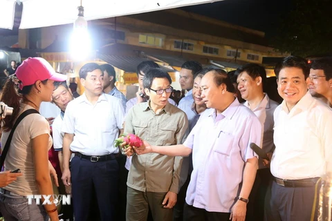 Thủ tướng Nguyễn Xuân Phúc đi kiểm tra vệ sinh an toàn thực phẩm tại chợ đầu mối Long Biên. (Ảnh: Thống Nhất/TTXVN)