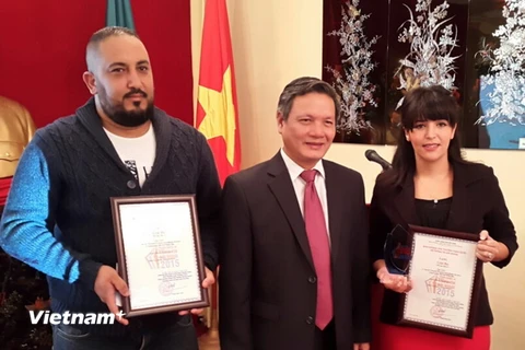 Đại sứ Phạm Quốc Trụ trao giải cho 2 nahf báo Algeria. (Ảnh: Thanh Bình/Vietnam+)