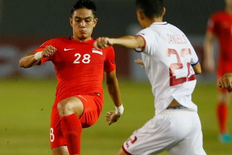 Singapore (áo đỏ) cầm hòa Philippines ở trận ra quân AFF Cup 2016 dù thiếu người. (Nguồn: AP)