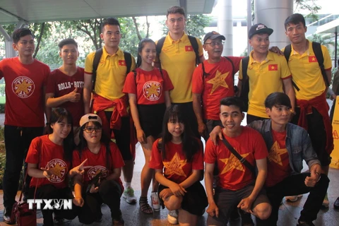 Các cầu thủ Đội tuyển bóng đá Việt Nam và người hâm mộ tại sân bay Tân Sơn Nhất. (Ảnh: Xuân Dự/TTXVN)