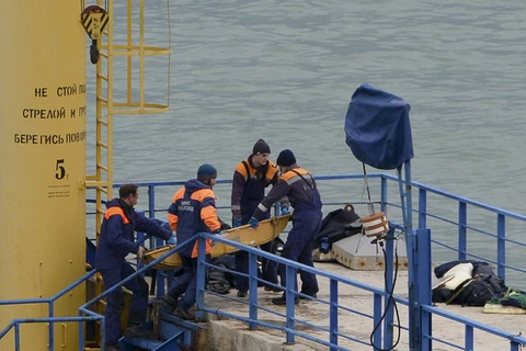 Lực lượng cứu hộ đưa thi thể nạn nhân vào bờ. (Nguồn: AP)