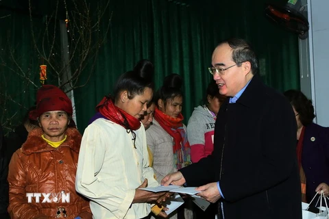 Chủ tịch Uỷ ban Trung ương MTTQ Việt Nam Nguyễn Thiện Nhân tặng quà Tết cho gia đình nghèo ở bản tái định cư. (Ảnh: Nguyễn Dân/TTXVN)