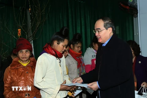 Chủ tịch Ủy ban Trung ương MTTQ Việt Nam Nguyễn Thiện Nhân tặng quà Tết cho gia đình nghèo ở bản tái định cư. (Ảnh: Nguyễn Dân -TTXVN)