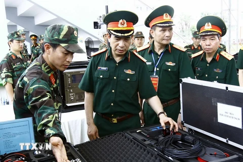 Trung tướng Phan Văn Giang với các đại biểu thăm khu trưng bày vũ khí, thiết bị phục vụ chống khủng bố. (Ảnh: An Đăng/TTXVN)