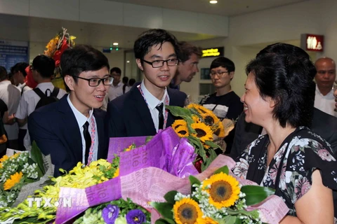 Người thân cùng các thầy cô chúc mừng thành tích của đoàn khi về tới sân bay Quốc tế Nội Bài Hà Nội. (Ảnh: Quý Trung/TTXVN)