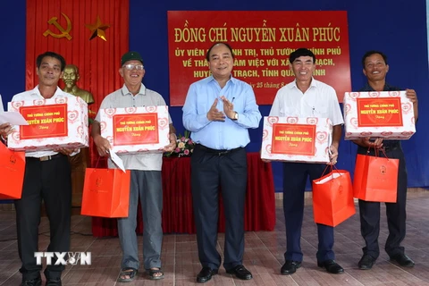 Thủ tướng Nguyễn Xuân Phúc tặng quà cho các thôn của xã Đức Trạch, huyện Bố Trạch. (Ảnh: Thống Nhất/TTXVN)