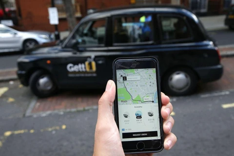 Một người cầm trên tay chiếc điện thoại có ứng dụng dịch vụ Uber ở London. (Nguồn: AFP/Getty Images)