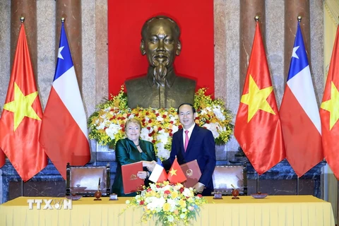 Chủ tịch nước Trần Đại Quang và Tổng thống nước Cộng hòa Chile Michelle Bachelet Jeria ký Tuyên bố chung. (Ảnh: Nhan Sáng/TTXVN)
