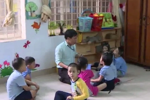 Thầy giáo Phan Văn Tính và các em nhỏ.