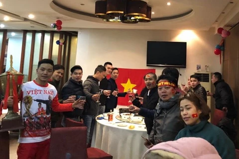 Cổ động viên Việt Nam treo cờ ở nhà hàng Trung Quốc ăn mừng chiến thắng. (Ảnh: HG/Vietnam+)