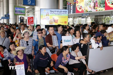 Thân nhân đón Việt kiều về quê đón Tết tại sân bay Tân Sơn Nhất. (Ảnh: Hoàng Hải/TTXVN)