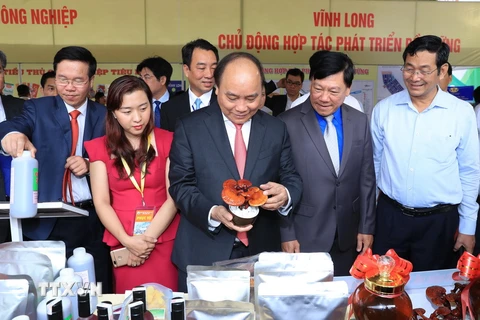 Thủ tướng Nguyễn Xuân Phúc thăm các gian hàng trưng bày, giới thiệu sản phẩm. (Ảnh: Thống Nhất/TTXVN)