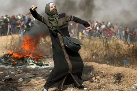 Một phụ nữ người Palestine chống trả quân đội Israel. (Nguồn: Reuters)