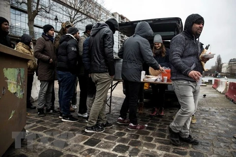 Người nhập cư xếp hàng nhận lương thực cứu trợ tại một khu trại tạm ở thủ đô Paris, Pháp ngày 2/1. (Nguồn: EPA-EFE/TTXVN)