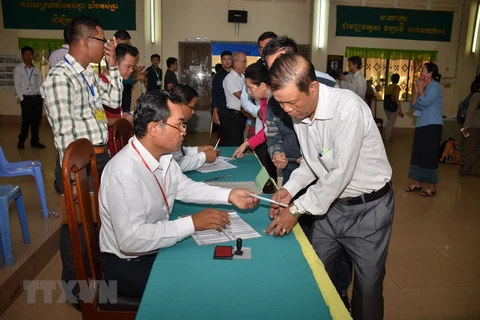 Cử tri làm thủ tục kiểm tra và nhận phiếu bầu tại phòng phiếu số 1697 ở thành phố Ta Khmau, tỉnh Kandal. (Ảnh: TTXVN)