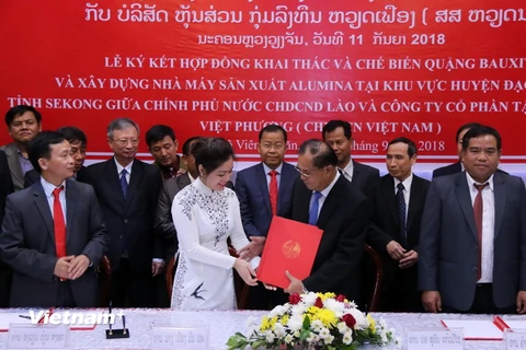 Bộ trưởng Kế hoạch và Đầu tư Lào, ông Suphan Keomisay và bà Phương Minh Huệ, Tổng Giám đốc Tập đoàn đầu tư Việt Phương đang trao cho nhau Hợp đồng tại lễ ký. (Ảnh: Kiên Phạm/Vietnam+)