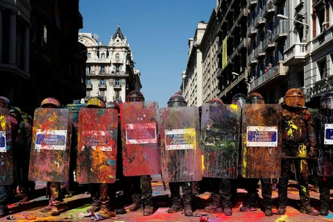 Lực lượng an ninh bị nhóm biểu tình ném sơn vào người. (Nguồn: Reuters)