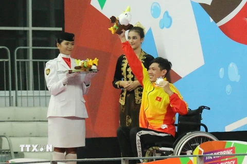 Võ Thanh Tùng (áo vàng) nhận huy chương bạc Asian Para Games 2018. (Ảnh: Hải Ngọc/TTXVN)