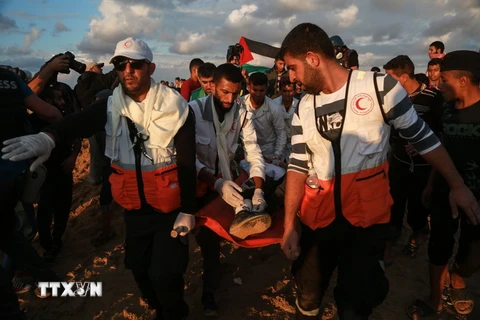 Nhân viên y tế chuyển người biểu tình Palestine bị thương trong cuộc xung đột với binh sỹ Israel ngày 9/11/2018. (Ảnh: AFP/TTXVN)