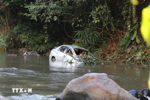 Sau khi lao xuống vực hơn 30m, chiếc xe bị tai nạn ngập trong nước của sông Nậm Rốm. (Ảnh: Xuân Tiến/TTXVN)