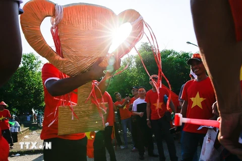 Cổ động viên mang theo biểu tượng Cup vô địch để cổ vũ tinh thần cho đội tuyển Việt Nam. (Ảnh: Trọng Đạt/TTXVN)